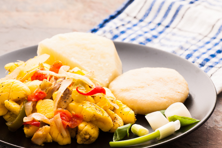 A dish of ackee and salt fish served with boiled dumplings and yams.